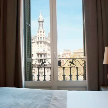 Bed and balcony in a clear day of the Adapted Exterior Room with Balcony